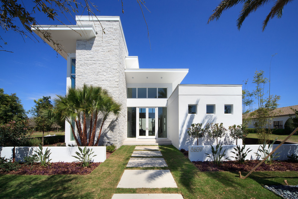 Ispirazione per la facciata di una casa bianca contemporanea con rivestimenti misti