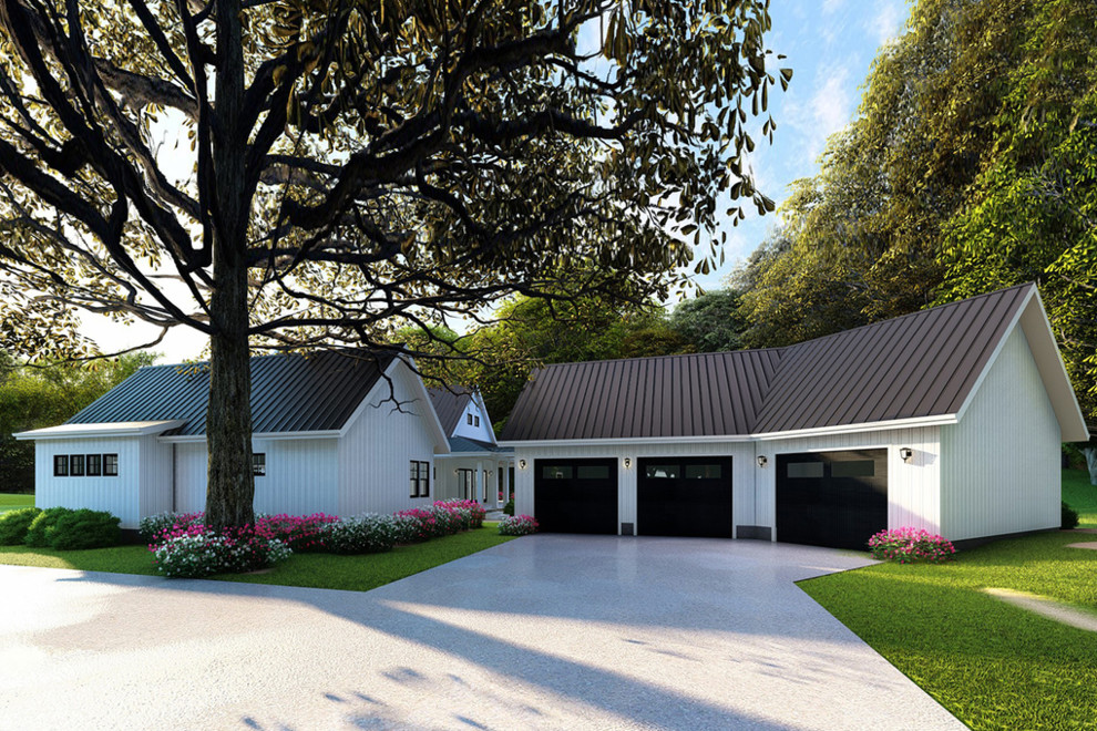Foto della villa grande bianca country a due piani con rivestimento in legno, tetto a capanna e copertura in metallo o lamiera