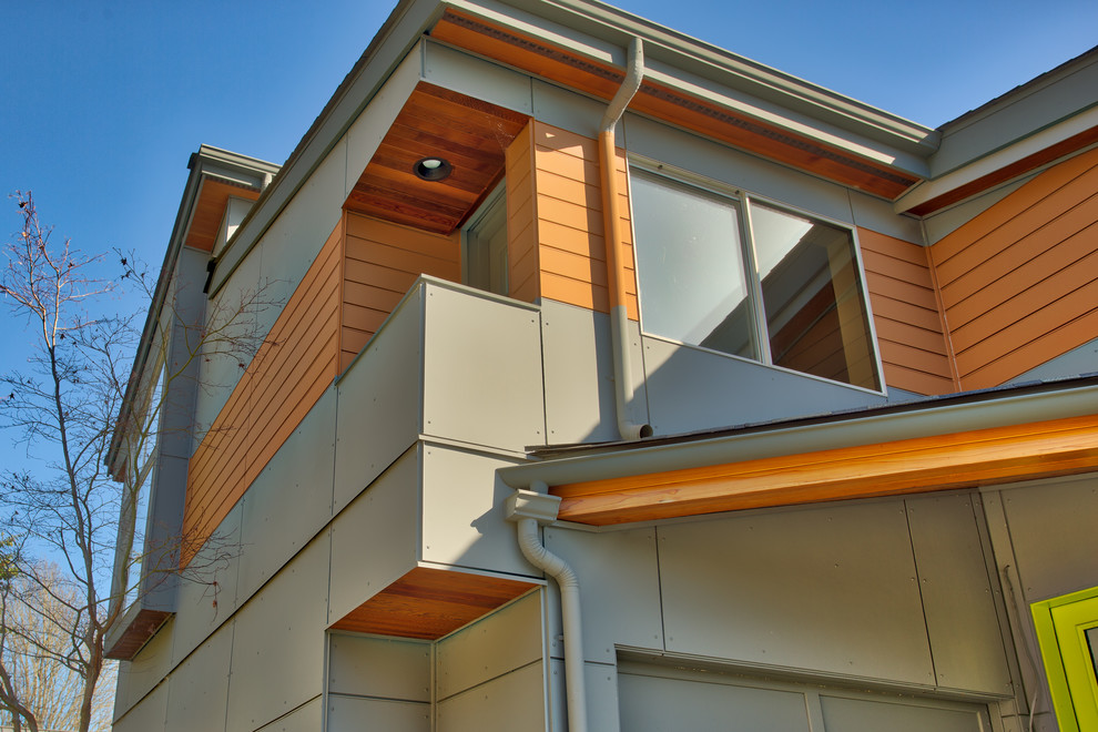Ejemplo de fachada de casa moderna pequeña de dos plantas con revestimiento de aglomerado de cemento