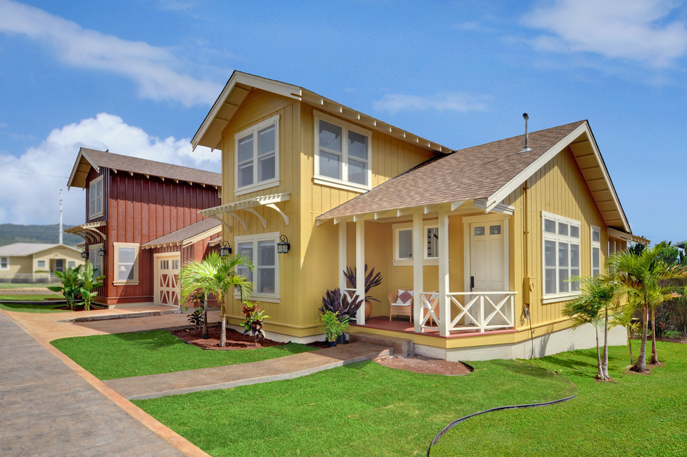 Idee per la villa gialla tropicale a due piani di medie dimensioni con rivestimento in legno, tetto a capanna e copertura a scandole