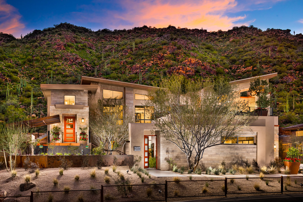 Example of a huge southwest beige two-story stone exterior home design in Phoenix with a mixed material roof