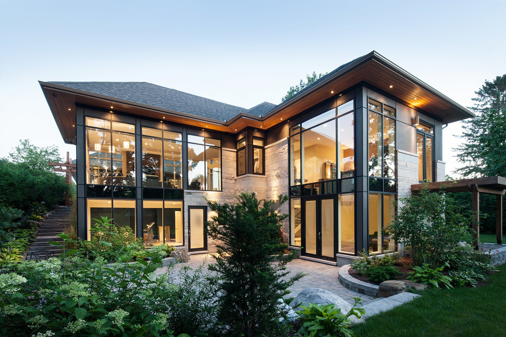 オタワにあるコンテンポラリースタイルのおしゃれな家の外観 (ガラスサイディング、外階段) の写真