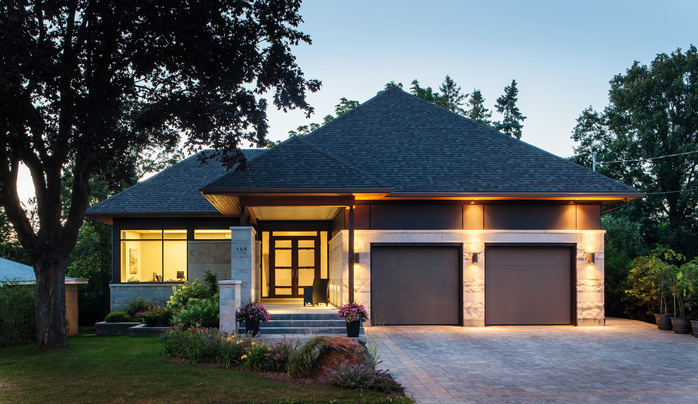 Cette photo montre une façade de maison tendance de plain-pied avec un revêtement mixte et un toit à quatre pans.