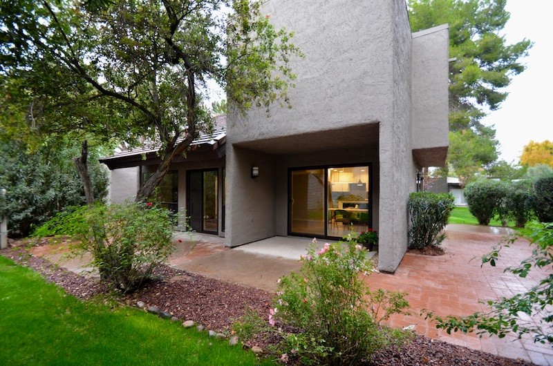 Example of a mid-sized 1950s beige two-story stucco flat roof design in Phoenix