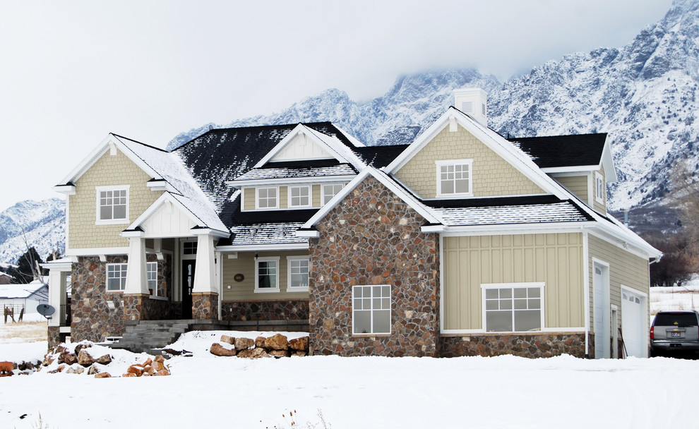 Immagine della facciata di una casa grande marrone american style a due piani con rivestimento in pietra e tetto a capanna