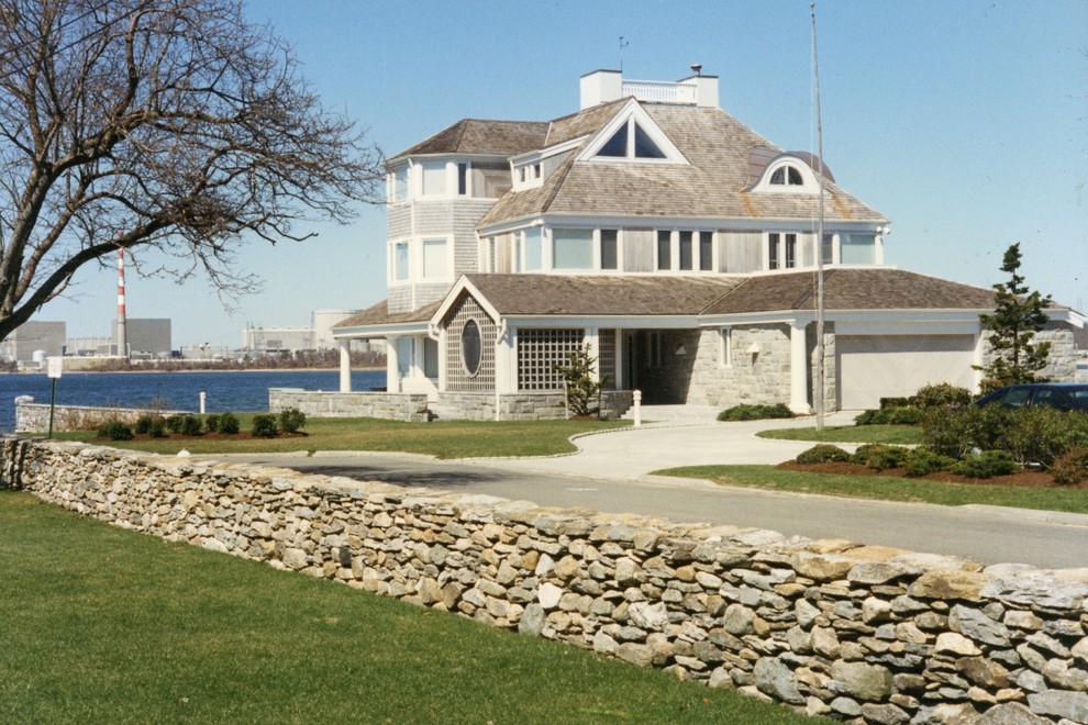 Пример оригинального дизайна: большой, трехэтажный, деревянный, серый частный загородный дом в морском стиле с крышей из гибкой черепицы