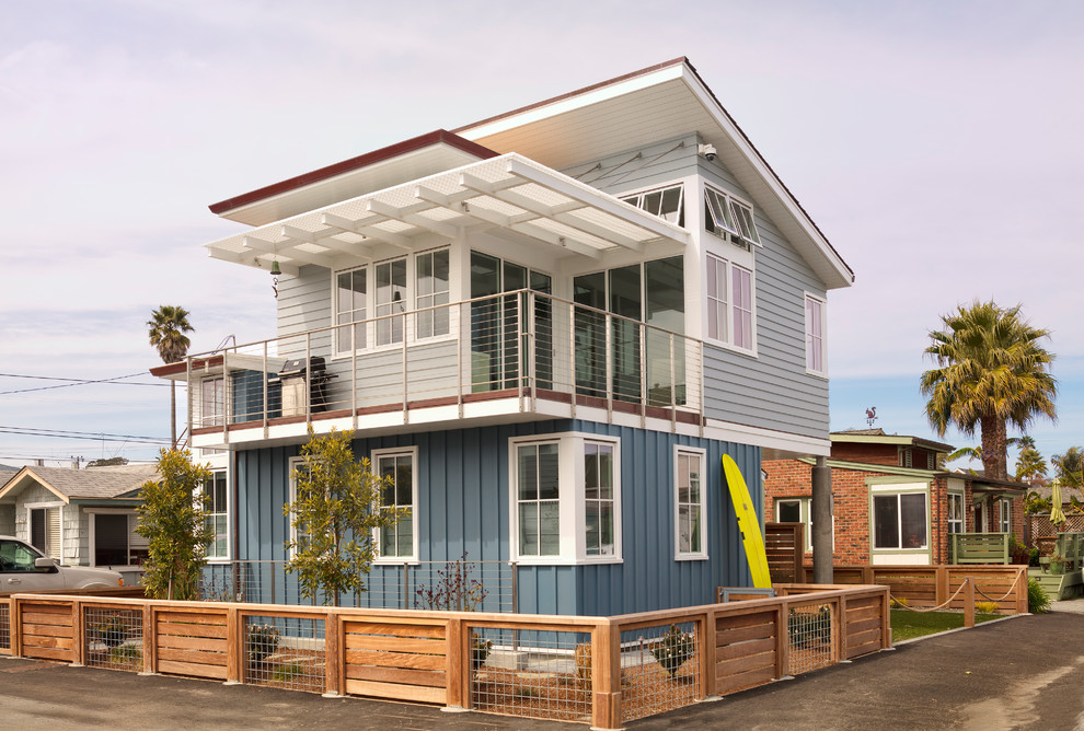 Стильный дизайн: маленький, двухэтажный, разноцветный частный загородный дом в морском стиле с комбинированной облицовкой, односкатной крышей и крышей из смешанных материалов для на участке и в саду - последний тренд