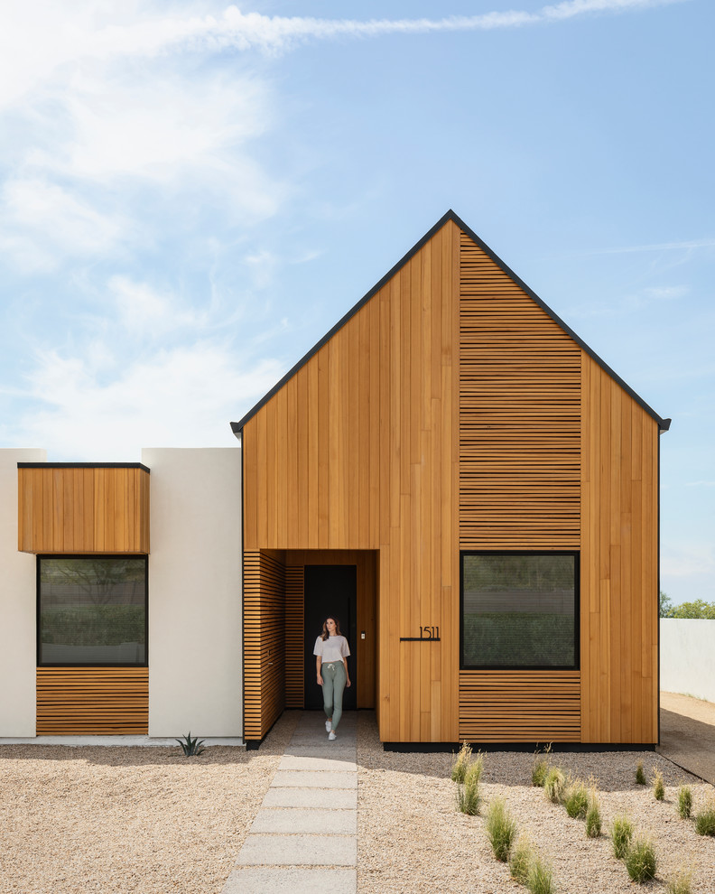 Идея дизайна: одноэтажный, деревянный частный загородный дом в стиле модернизм с двускатной крышей и металлической крышей