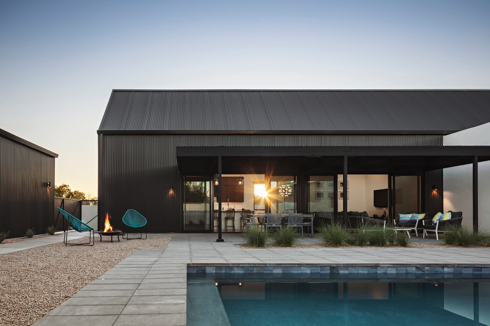 Imagen de fachada de casa minimalista de una planta con revestimiento de madera, tejado a dos aguas y tejado de metal