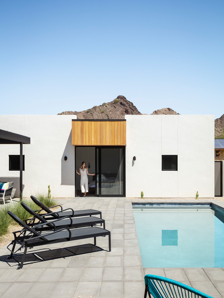 Cette photo montre une façade de maison moderne en bois de plain-pied avec un toit à deux pans et un toit en métal.