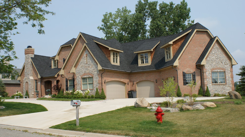 Inspiration for a large and red traditional two floor brick house exterior in Detroit with a pitched roof.