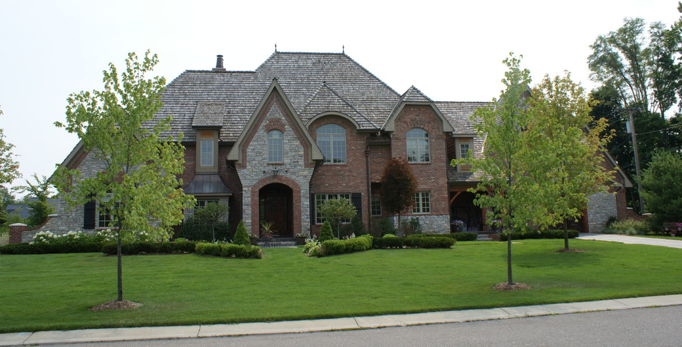 Photo of a large and red classic house exterior in Detroit with three floors, mixed cladding and a hip roof.
