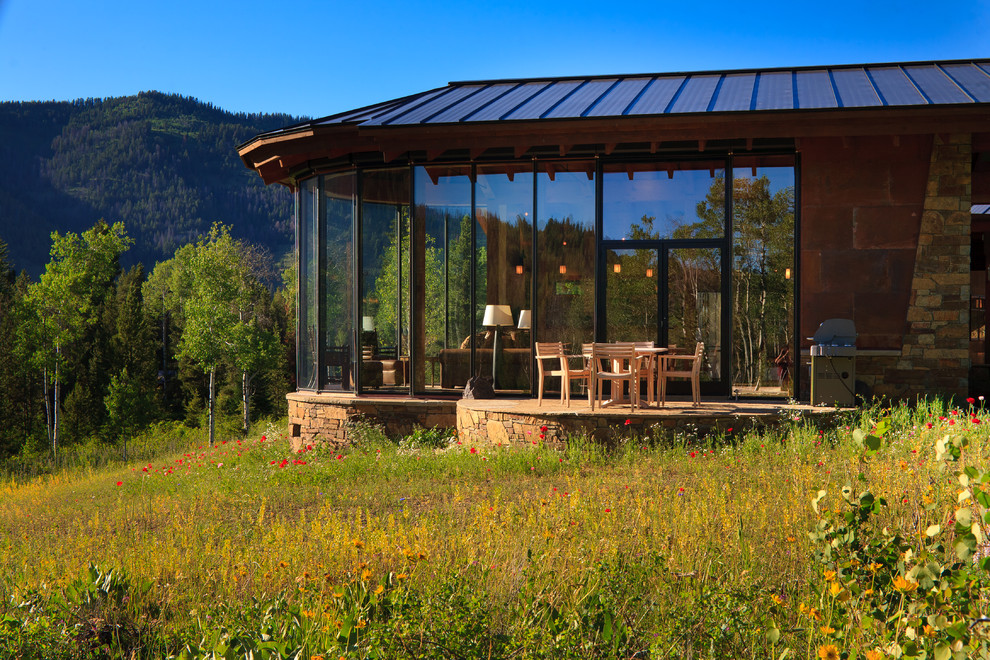 Inspiration for a rustic one-story glass exterior home remodel in Denver