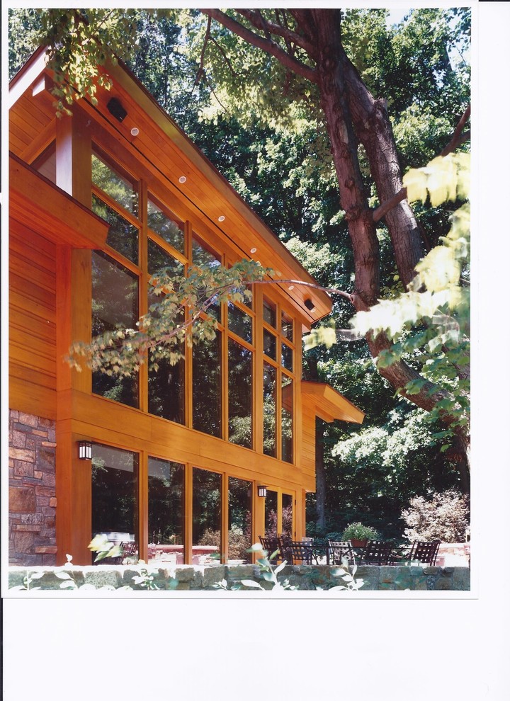 Foto della facciata di una casa ampia marrone american style a piani sfalsati con rivestimento in legno e falda a timpano