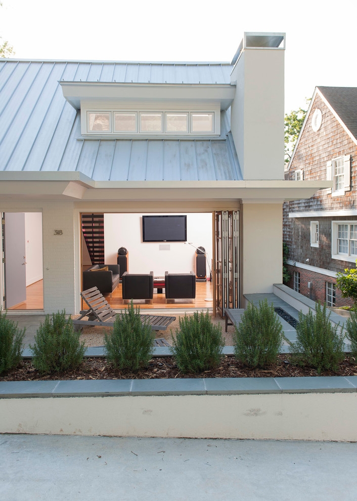 Imagen de fachada de casa blanca clásica renovada pequeña de dos plantas con revestimiento de estuco, tejado a dos aguas y tejado de metal