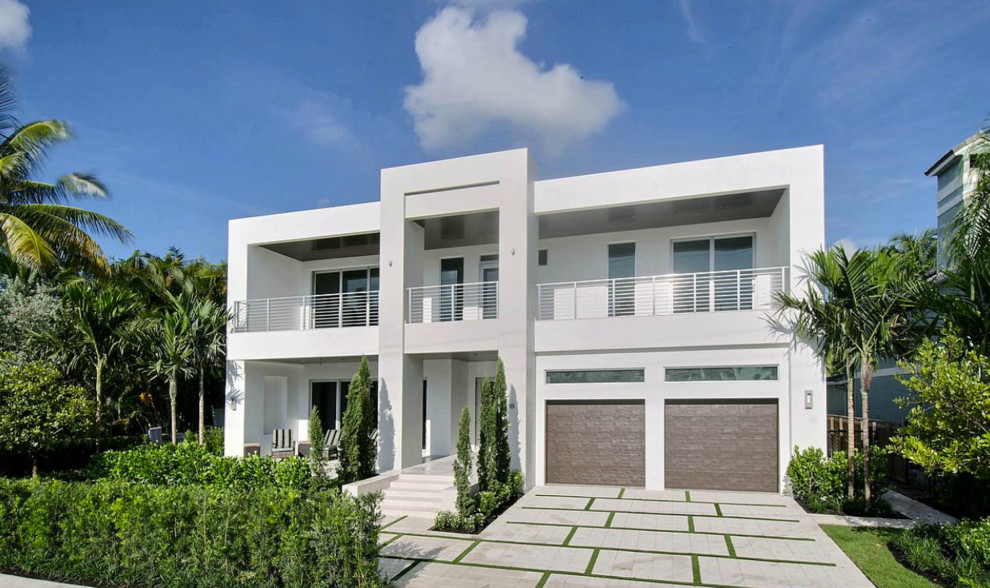 Aménagement d'une façade de maison blanche moderne en stuc de taille moyenne et à un étage avec un toit plat.