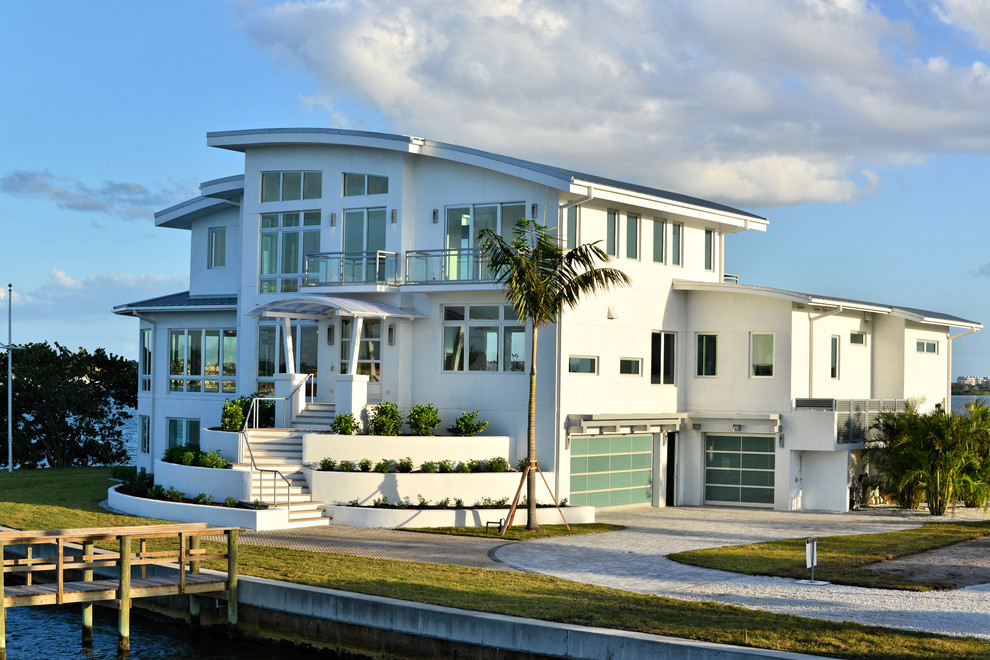 Источник вдохновения для домашнего уюта: огромный, трехэтажный, белый дом в морском стиле с односкатной крышей