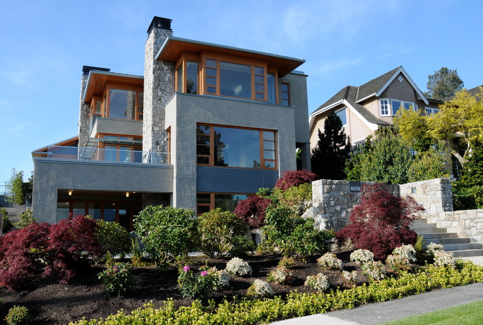 Réalisation d'une façade de maison grise design à deux étages et plus avec un revêtement mixte.