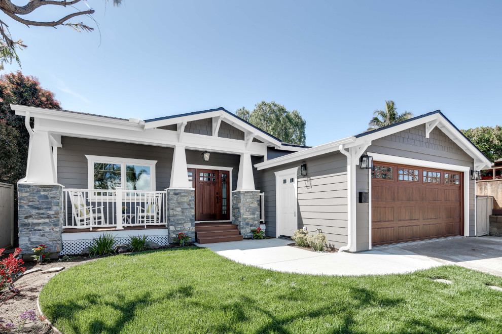 This is an example of an expansive and gey contemporary bungalow detached house in San Diego with wood cladding, a flat roof and a shingle roof.