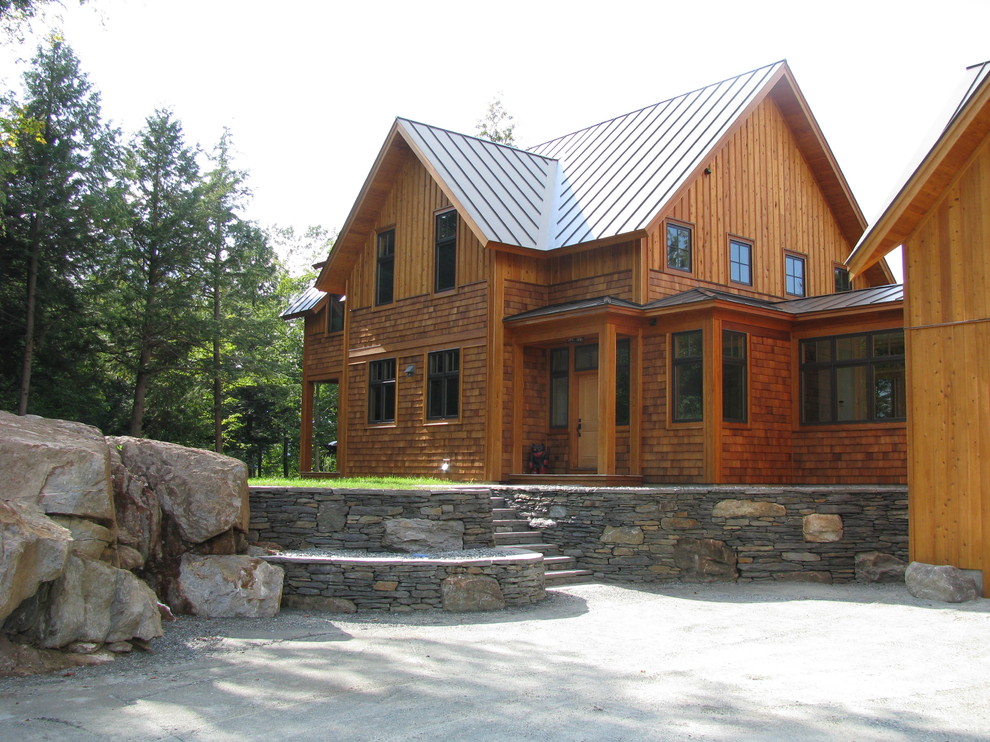 Réalisation d'une façade de maison chalet en bois à deux étages et plus avec un toit à deux pans et un toit en métal.