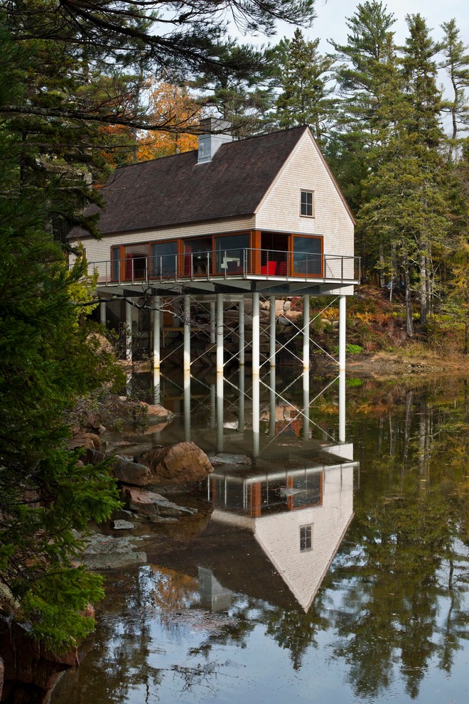 Пример оригинального дизайна: одноэтажный, деревянный, серый дом среднего размера в стиле неоклассика (современная классика) с двускатной крышей