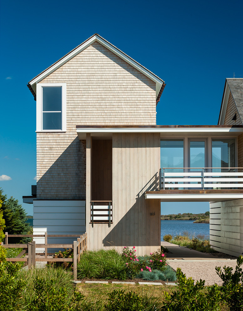 Diseño de fachada costera con revestimiento de madera y tejado a dos aguas