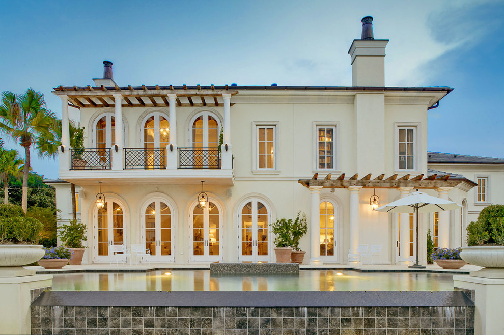 Idées déco pour une façade de maison beige méditerranéenne à un étage.