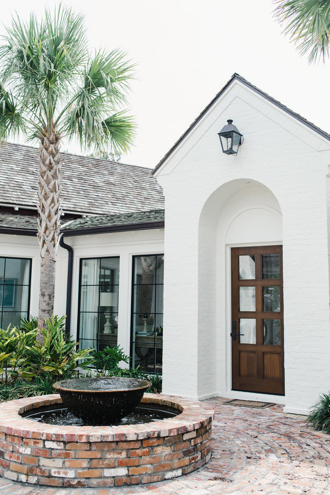 Inspiration for a large contemporary white two-story brick exterior home remodel in Jacksonville with a shingle roof