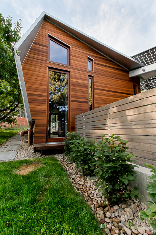 Mittelgroße, Einstöckige Moderne Holzfassade Haus mit oranger Fassadenfarbe, Pultdach und Blechdach in Denver
