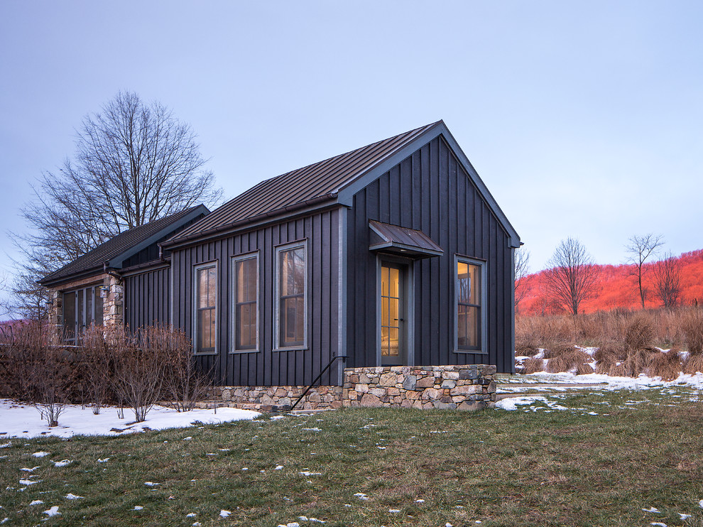 На фото: маленький, одноэтажный, черный дом в современном стиле с комбинированной облицовкой и двускатной крышей для на участке и в саду
