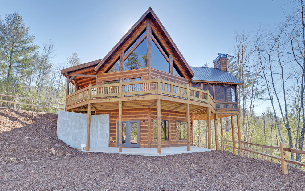 Diseño de fachada de casa marrón rural de tamaño medio de tres plantas con revestimiento de madera y tejado de metal