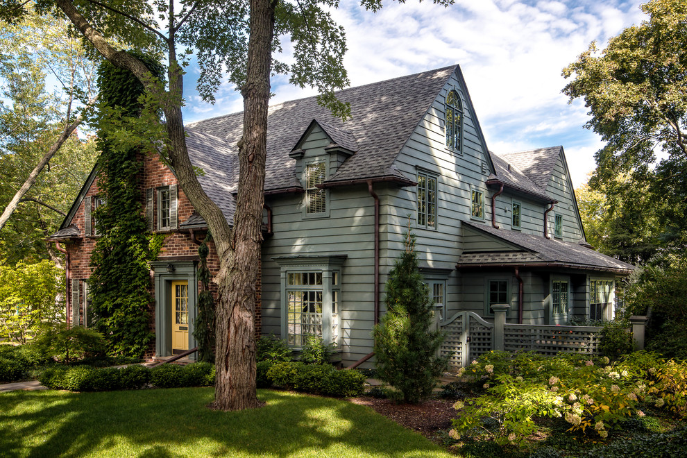Diseño de fachada de casa verde clásica extra grande de dos plantas con revestimiento de madera, tejado a dos aguas y tejado de teja de madera