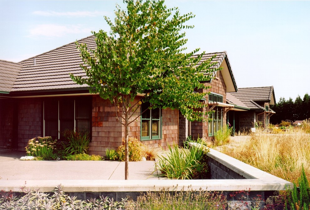 Foto på ett amerikanskt brunt trähus, med allt i ett plan och valmat tak