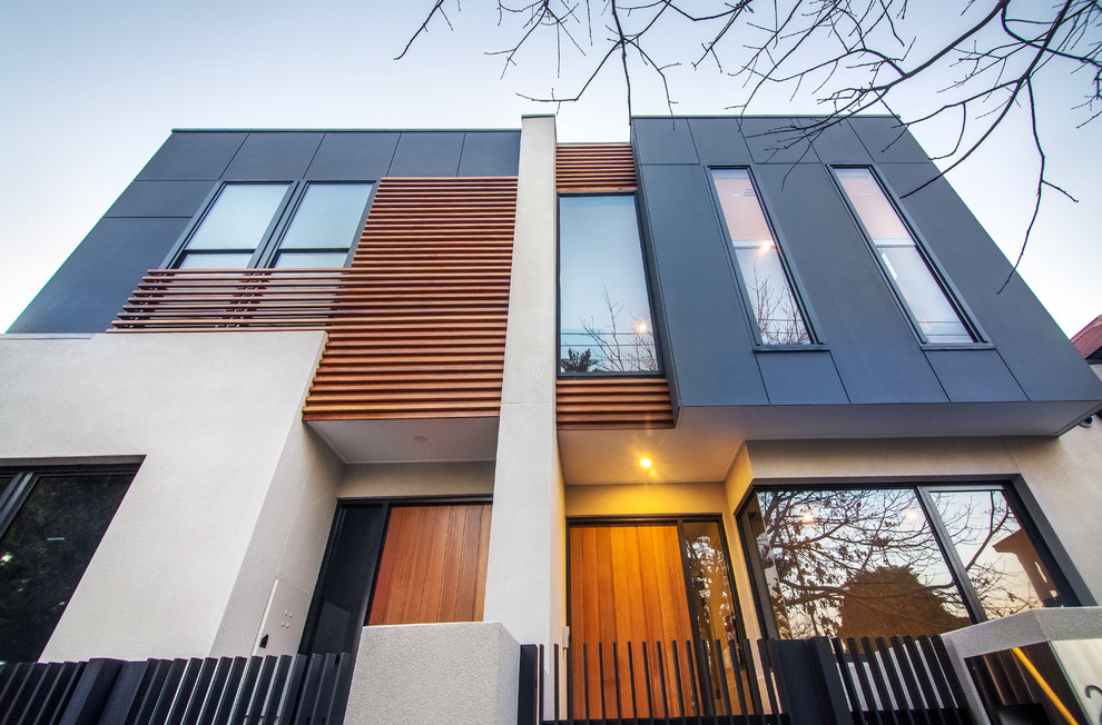 Diseño de fachada de casa bifamiliar contemporánea de tamaño medio de dos plantas con revestimientos combinados y tejado plano
