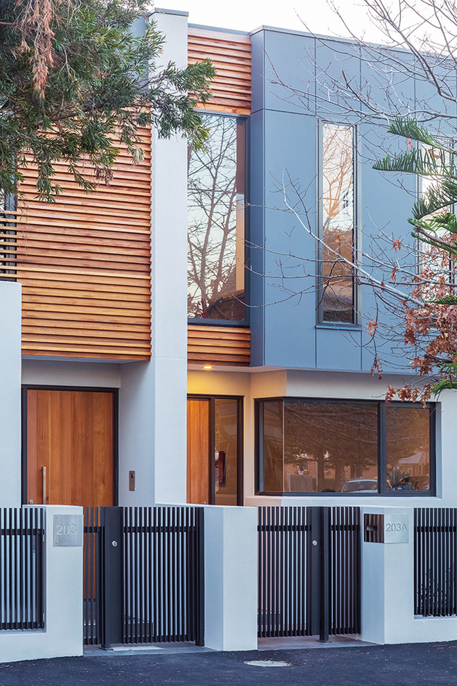 This is an example of a medium sized contemporary two floor house exterior in Melbourne with mixed cladding and a flat roof.