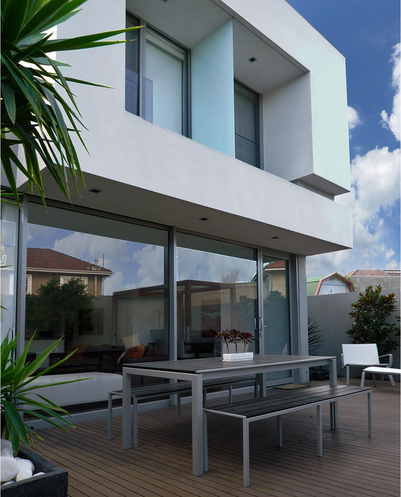 Exemple d'une façade de maison grise tendance en béton de taille moyenne et à un étage avec un toit plat et un toit en métal.
