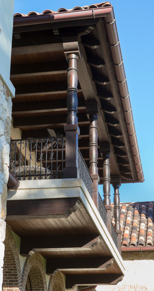 Modelo de fachada de casa beige mediterránea grande de dos plantas con revestimientos combinados, tejado a dos aguas y tejado de teja de barro