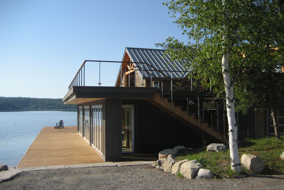 На фото: двухэтажный, деревянный, серый дом среднего размера в стиле модернизм с двускатной крышей с