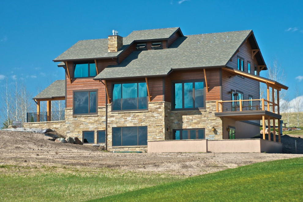 Imagen de fachada de casa marrón de estilo americano de tamaño medio de tres plantas con revestimientos combinados y tejado a dos aguas