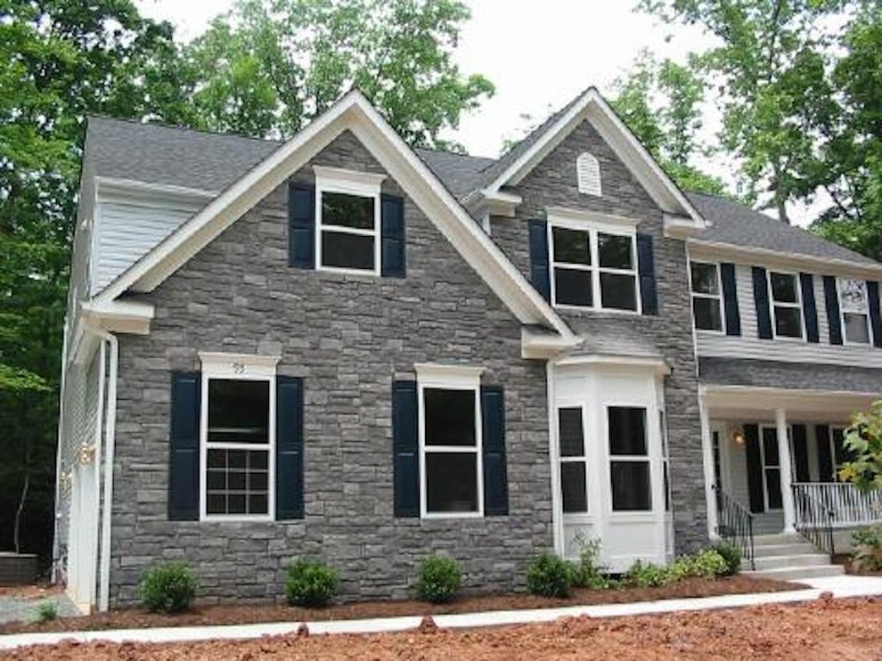 Medium sized and gey traditional two floor house exterior in Richmond with stone cladding.