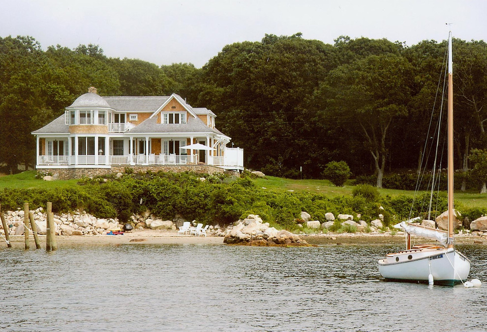 Cette photo montre une grande façade de maison marron bord de mer à un étage.