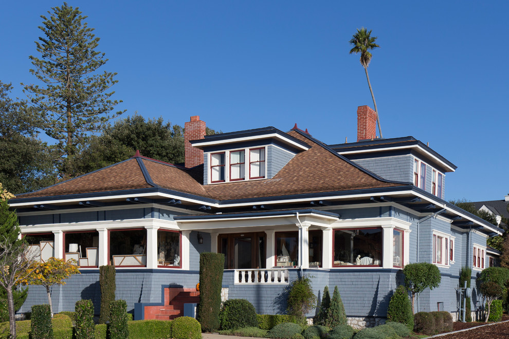 Foto della facciata di una casa grande blu american style a due piani con rivestimento in legno e tetto a padiglione