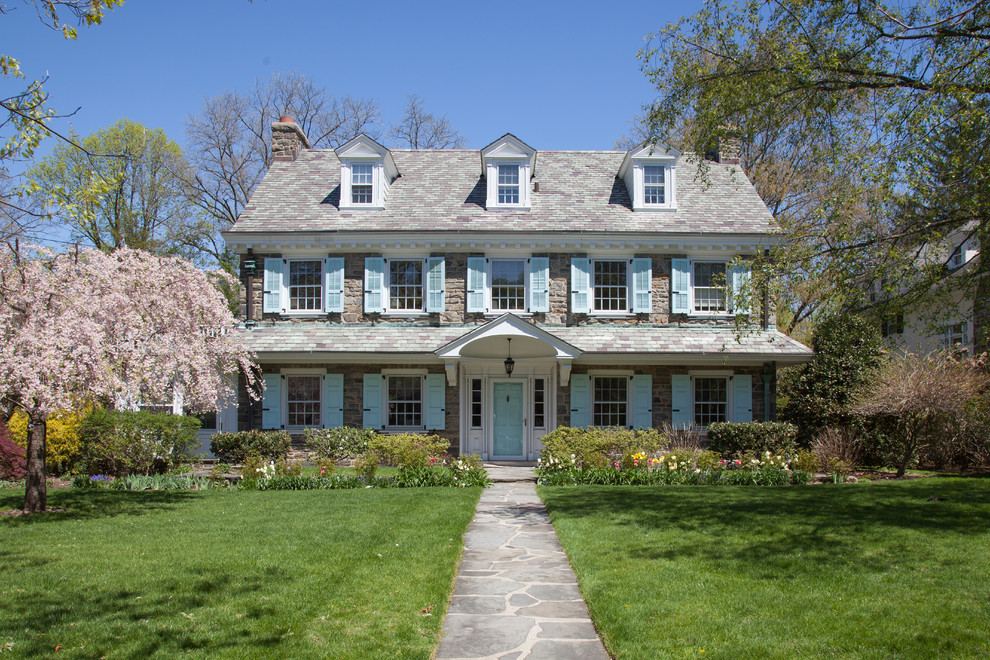 This is an example of a classic house exterior in New York with three floors, stone cladding and a pitched roof.