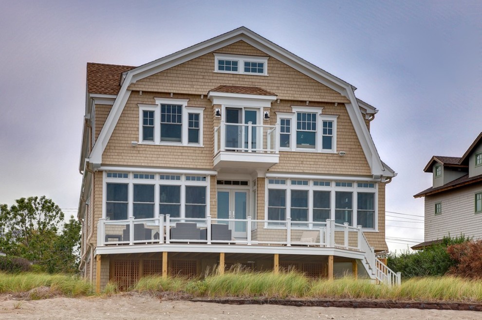 Idées déco pour une grande façade de maison beige bord de mer en bois à deux étages et plus avec un toit de Gambrel.