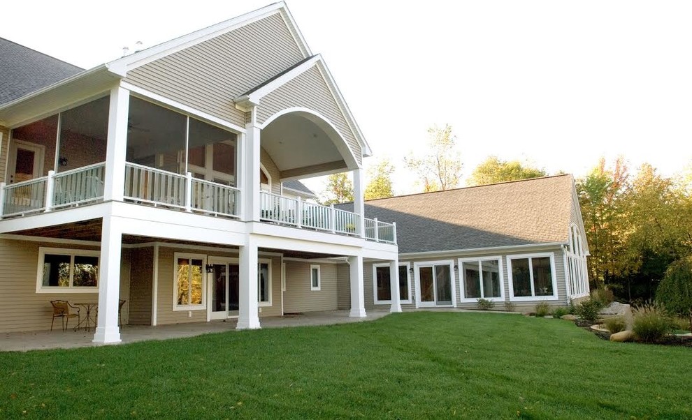 Example of a large minimalist beige two-story vinyl gable roof design in Grand Rapids