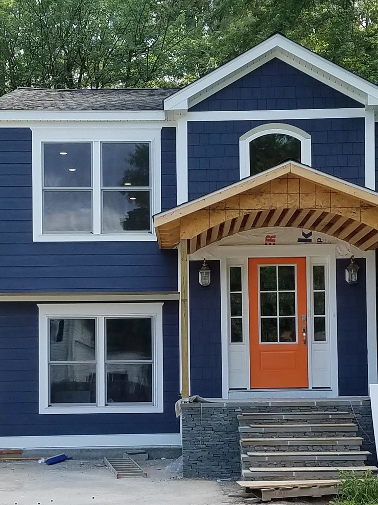 Aménagement d'une façade de maison bleue classique à niveaux décalés avec un revêtement mixte, un toit à deux pans et un toit en shingle.