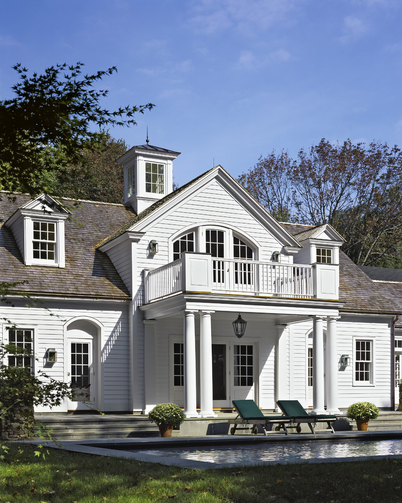 Immagine della facciata di una casa grande bianca classica a due piani con rivestimento in legno