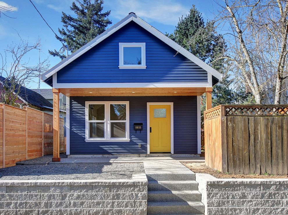 Imagen de fachada de casa azul clásica pequeña de una planta con revestimiento de madera, tejado a dos aguas y tejado de teja de madera