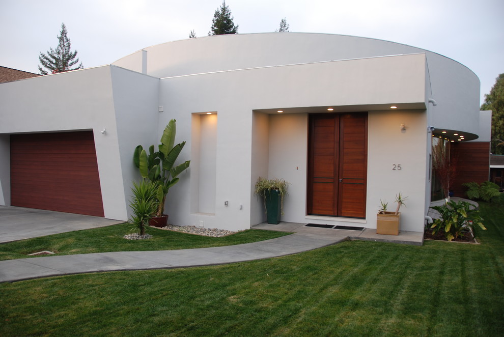Imagen de fachada de casa beige contemporánea de una planta con revestimiento de estuco