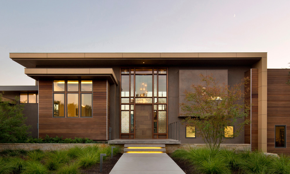 Esempio della facciata di una casa moderna con rivestimento in legno e tetto piano